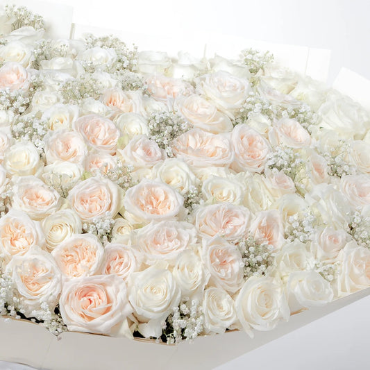 Amelia Grand bouquet with O’Hara roses, white roses, and delicate gypsophila, hand-tied in signature Grand wrap, available for flower delivery in Lahore