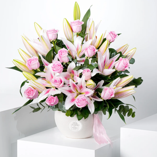 Blushing Blooms elegant vase arrangement with pink roses, soft pink lilies, and fresh greenery, available for flower delivery in Lahore