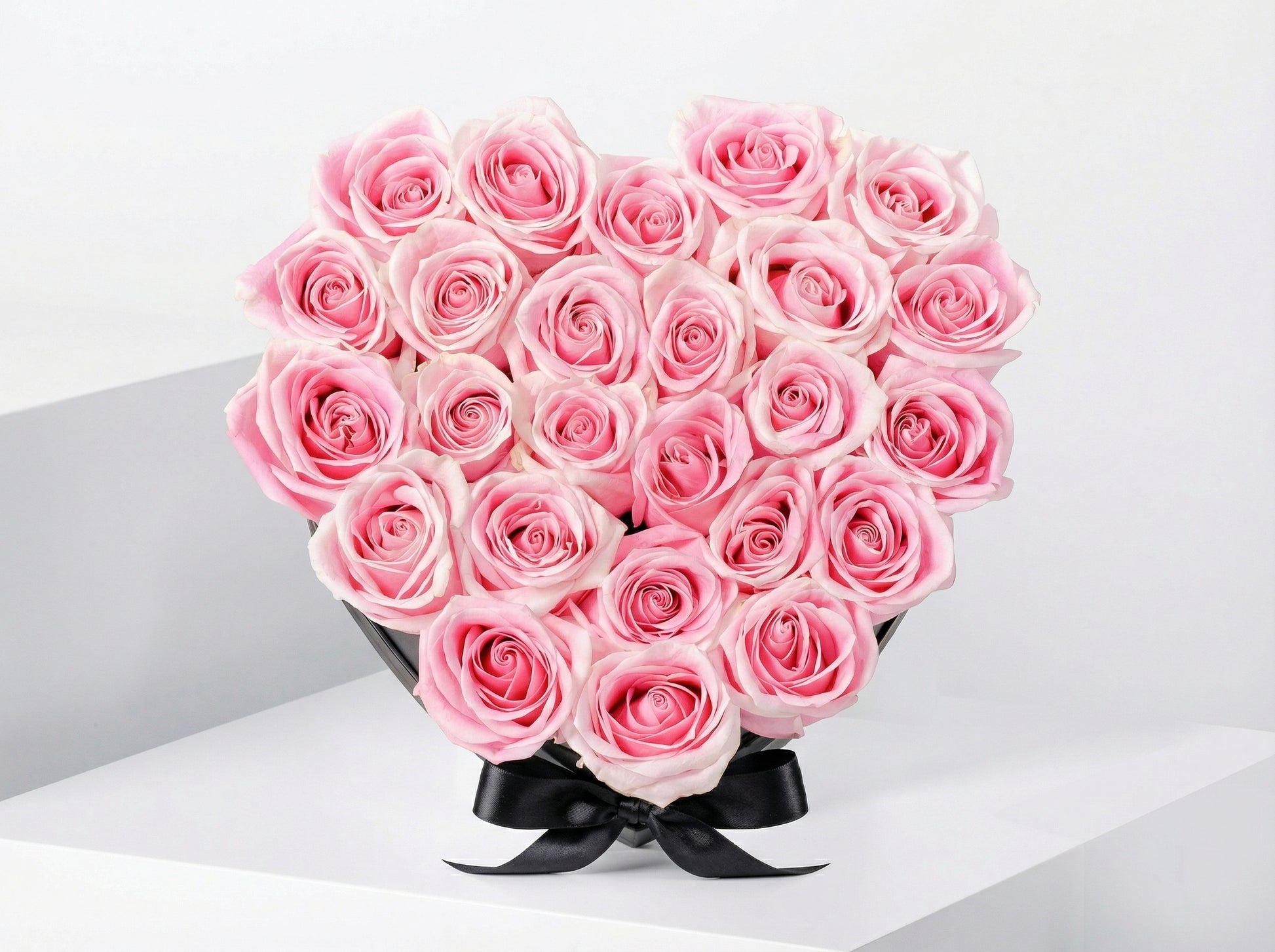 20-25 fresh pink roses arranged in a heart-shaped box for Valentine’s Day delivery in Lahore